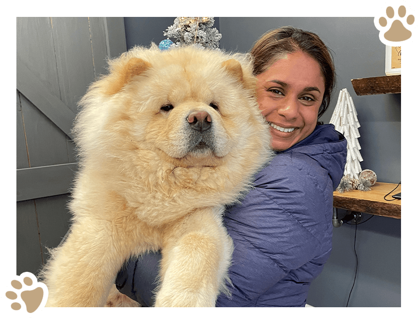 A woman holding a large white dog in her arms.